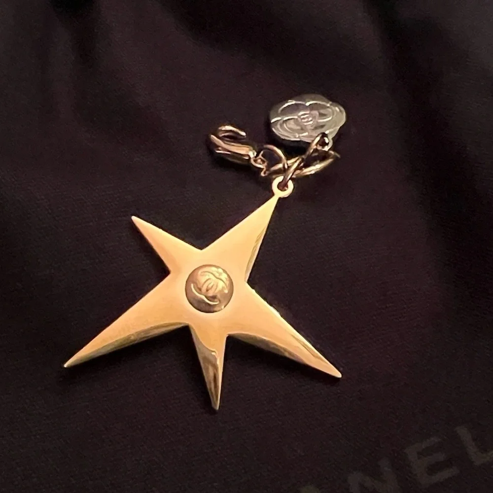 CHANEL Gold Star & small Camellia key Charm with black drawstring pouch.